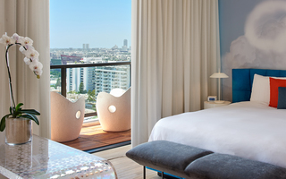 the mondrian bedroom featuring two white armchairs on the outdoor balcony in the suite