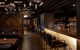 dirty habit sf bar and dining tables separated from the adjoined room with restaurant seating by an industrial wooden barn door