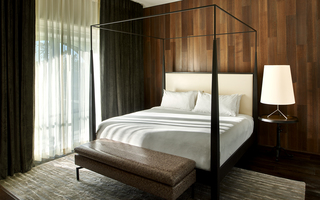union station nashville model room bed with black frame canopy and wood wallcovering in the back