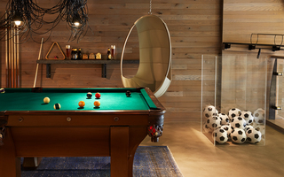 hotel zetta upstairs game room with pool table to the left and basket of soccer balls to the right