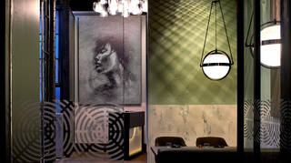 dirty habit dc view of the hostess desk from the restaurant tables. On the wall hangs a mural with a ripple effect expanding from the center to the corners of the canvas. At center is the side profile of a woman closing her eyes