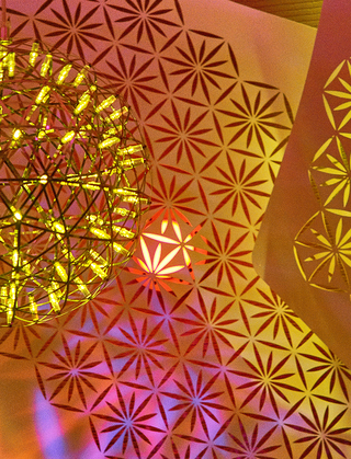 w la close-up of the decorative metal ceiling installation and dome light fixture above the reception desk