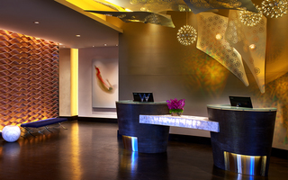 w la lobby reception desk with metal sheets of decorated flowers, dome light fixtures, and light installations on the ceiling