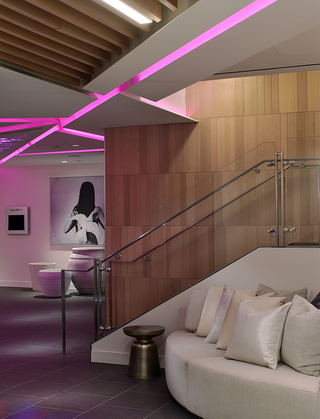 w la lounge seating in the hallway to the meeting room and in the distance hangs a mural of a woman with a white dove strapped to her back