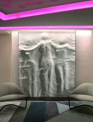 w la clay art mural of 3 figures hanging on the wall