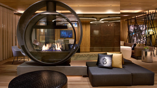 hotel palomar la lobby featuring a circular fireplace glass installation in front of the mirrored wall and surrounding the wall is ample seating