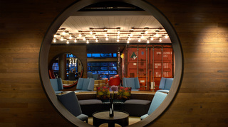 hotel zephyr circular cut out in the wooden wall looking out into the lobby seating area