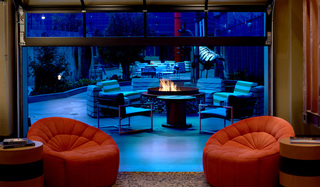 hotel zephyr glass paneled garage door facing the outdoor fire pit and seating