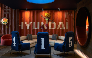 hotel zephyr lobby seating in the center and in the background, a metal cut out of a mermaid is hanging on a Hyundai crate wall