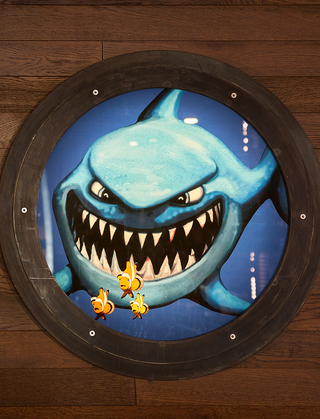 hotel zephyr circular mural of a shark chasing a few clown fish