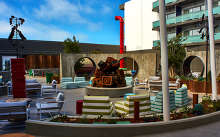 hotel zephyr outdoor seating and outdoor games surrounding the metal tv sculptures stacked in the main firepit