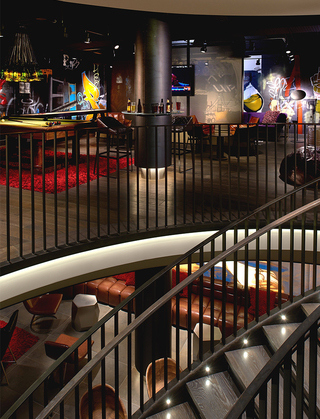 hotel vintage portland stair railing looking out into the game and lounge room featuring the pool table, shuffleboard table, tv, and an abundance of seating