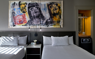 villa florence guestroom twin beds with a mural on the wall of Freddy Mercury and Kurt Cobain