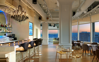 lizzie starlight bar and additional seating surrounded by a panoramic window view of the skylight