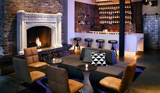 hotel zeppelin fireplace, leather seating, and a small bar in the back of the lobby