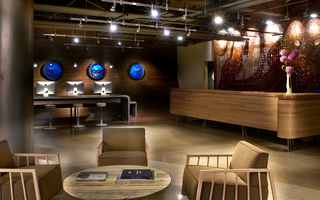 hotel zephyr lobby reception desk featuring 3 small circular shark murals hanging on the left wall and in front of the mural is a computer station area.