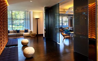 w la lobby seating area with a sofa and benches to the left and sliding panel doors leading into the lounge