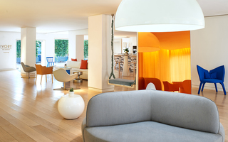 the mondrian swing chair in the lobby adjacent to the full-length orange iridescent mirror and round oversized grey lounge chair