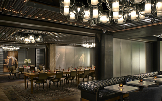 dirty habit sf wide angle of the long wood dining table in the middle of surrounding seating area and a mural of an elegant dancer in an arched upside-down U pose hangs on the back wall