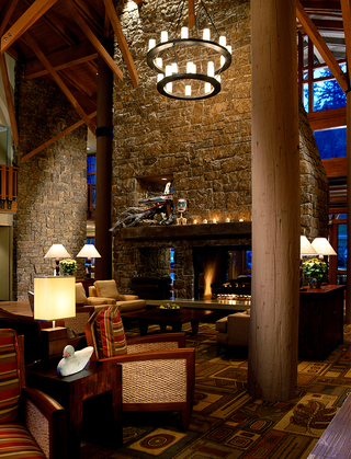 alderbrook lobby featuring a glass fireplace installed in the stone wall in front of the armchairs and wood tables in the lounge