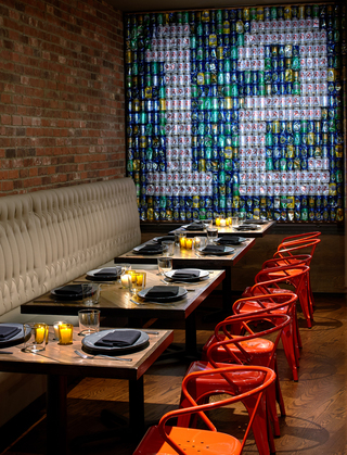 Outlier restaurant dining seating in front of an installation of beer bottles in the shape of the number 12 in Seahawks colors