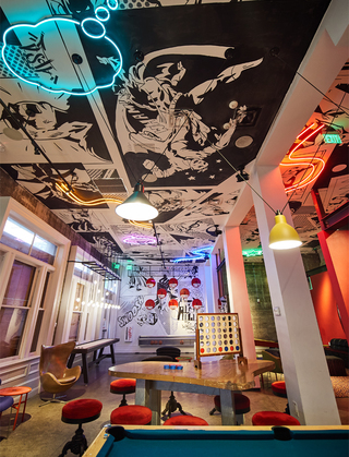 hotel zeppelin game room with a view of the comic book art and neon art displayed on the ceiling wall and displayed on the wall is the group of basketball hoops