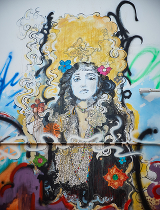 hotel zeppelin graffiti mural of a woman holding a cigarette in hand surrounded by colorful smoke and flowers