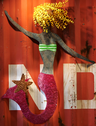 hotel zephyr close up of the metal cut out of a mermaid with yellow curly hair and a pink tail