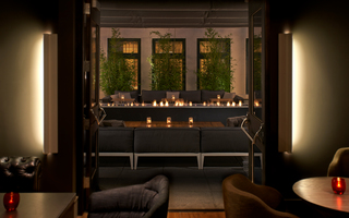 dirty habit sf opened doors leading out from the restaurant to the outdoor patio featuring a long rectangular fire table in the center of two grey sofas